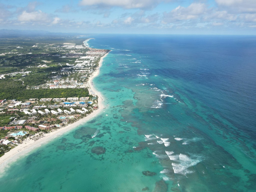 Aerial view of a long beach, reef, and the built coast