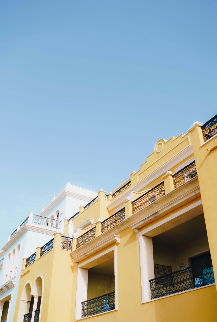 Yellow and pale-blue facades with iron balconies