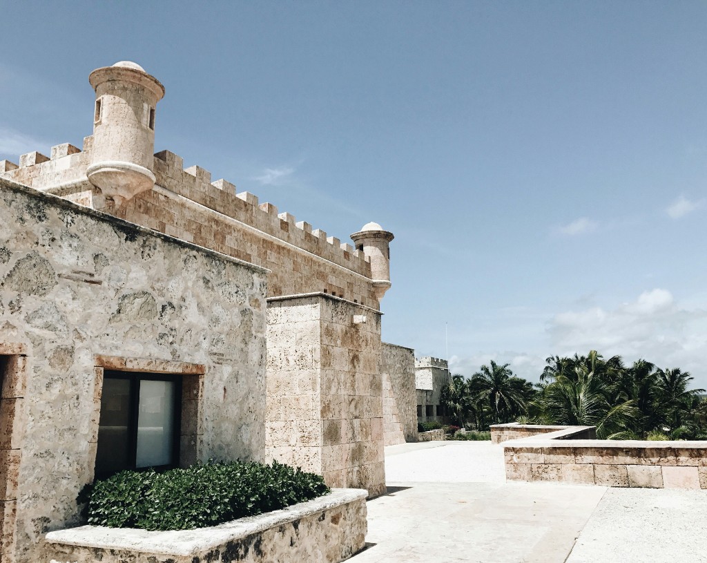 A stone fortification with palms beyond the wall