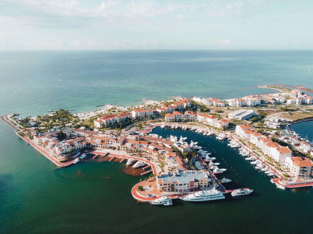 Aerial view of a marina, red roofs, and open sea