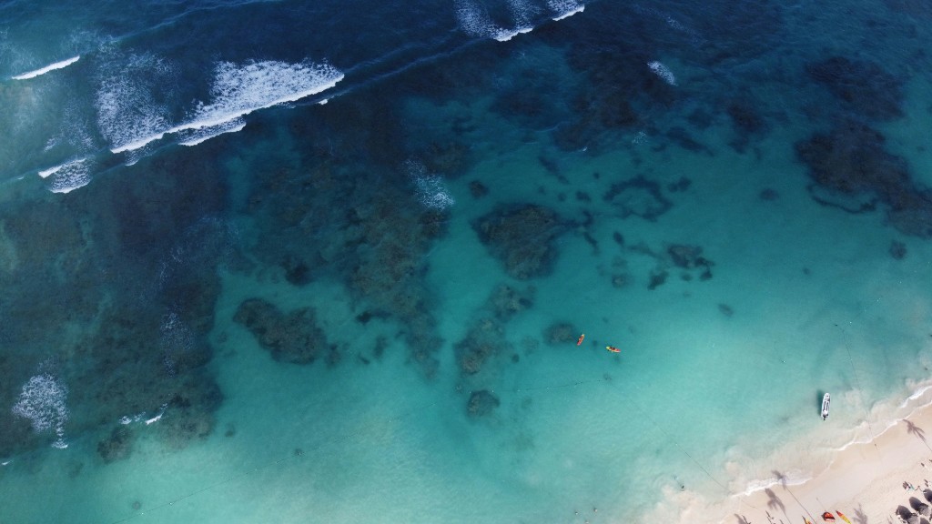 Aerial view of turquoise water, reef, and a pale sand beach